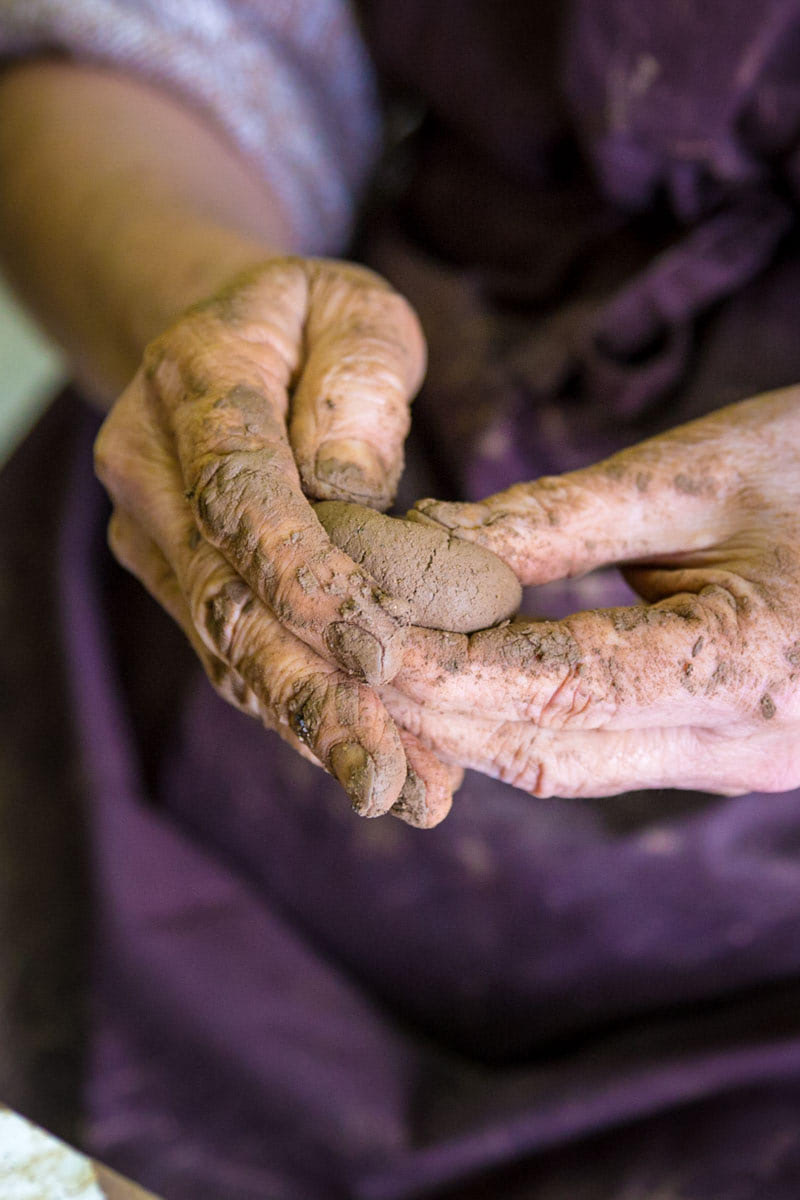 Mujer trabajando con las manos el barro para hacer cerámica.